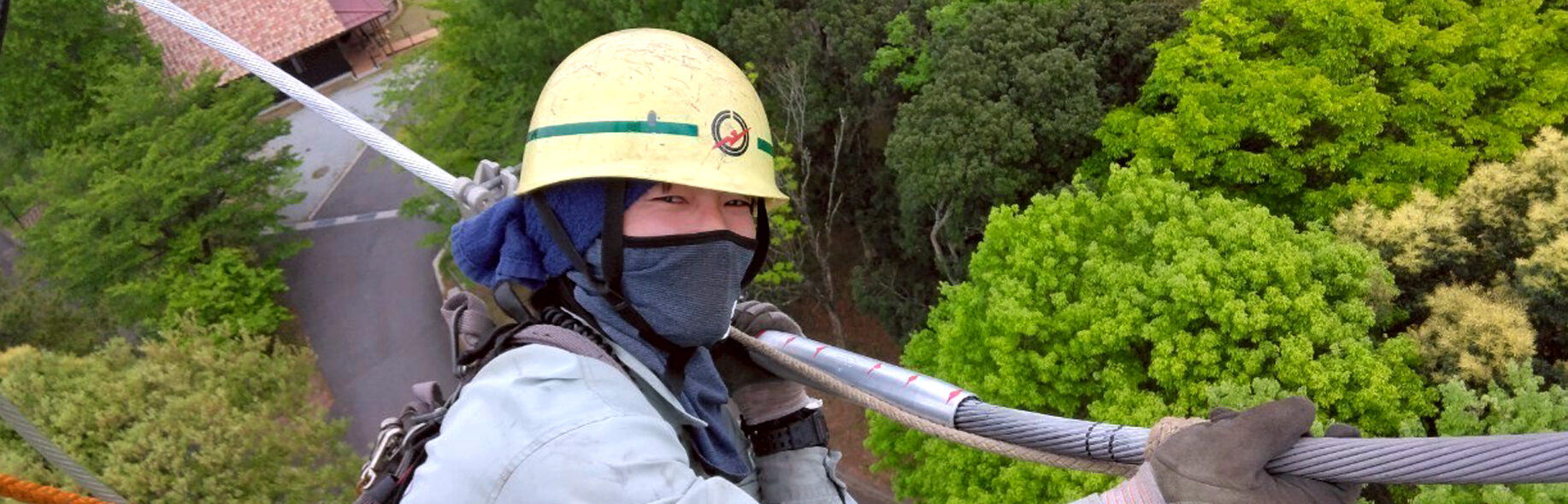 高所で電線作業をする写真