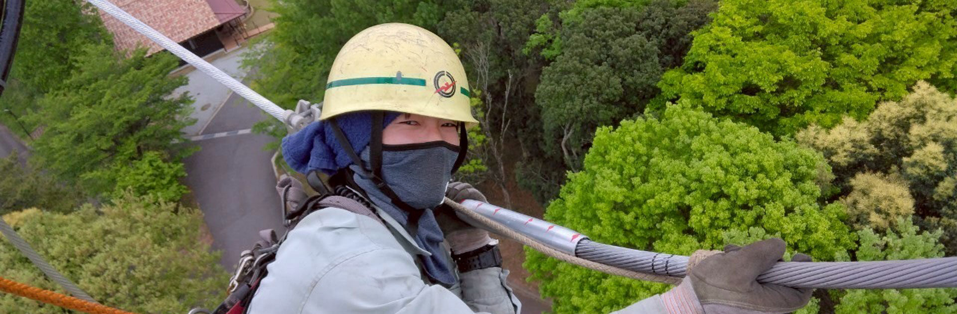 高所で電線作業をする写真