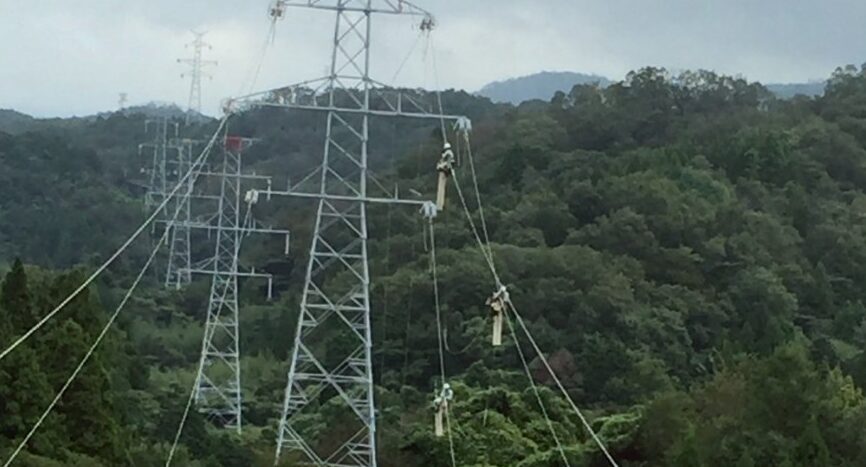 山間部に立ち並ぶ鉄塔で作業する様子