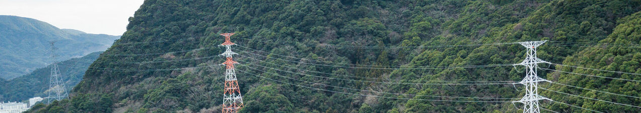 山間部に立つ鉄塔の写真